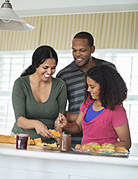 Happy African American family having breakfast at kitchen counter