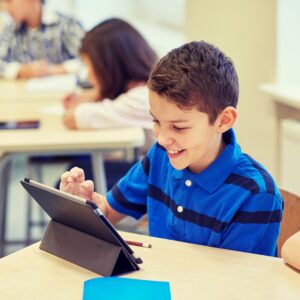 A happy student using a tablet in class