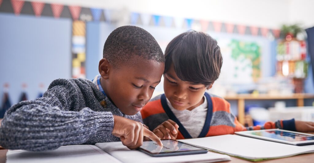 Two boys sharing a tablet in class