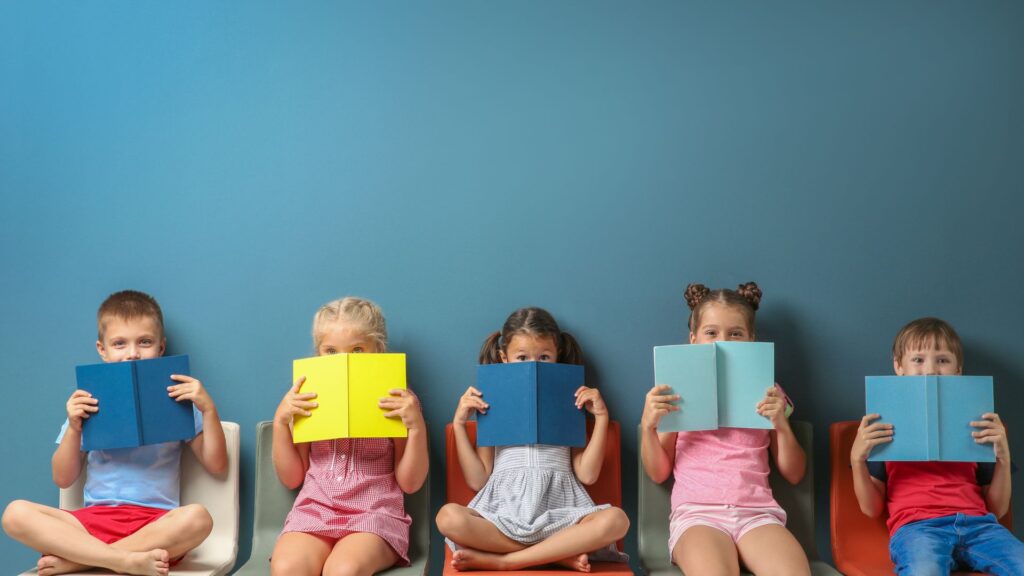 kids hiding their faces behind books