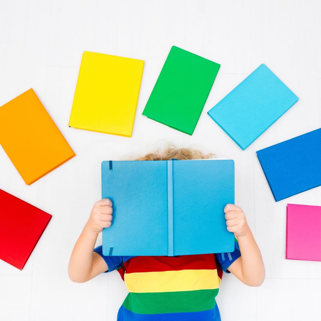 kid reading surrounded by multi-colored books