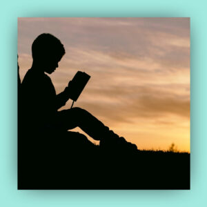 Silhouette of a kid reading a book